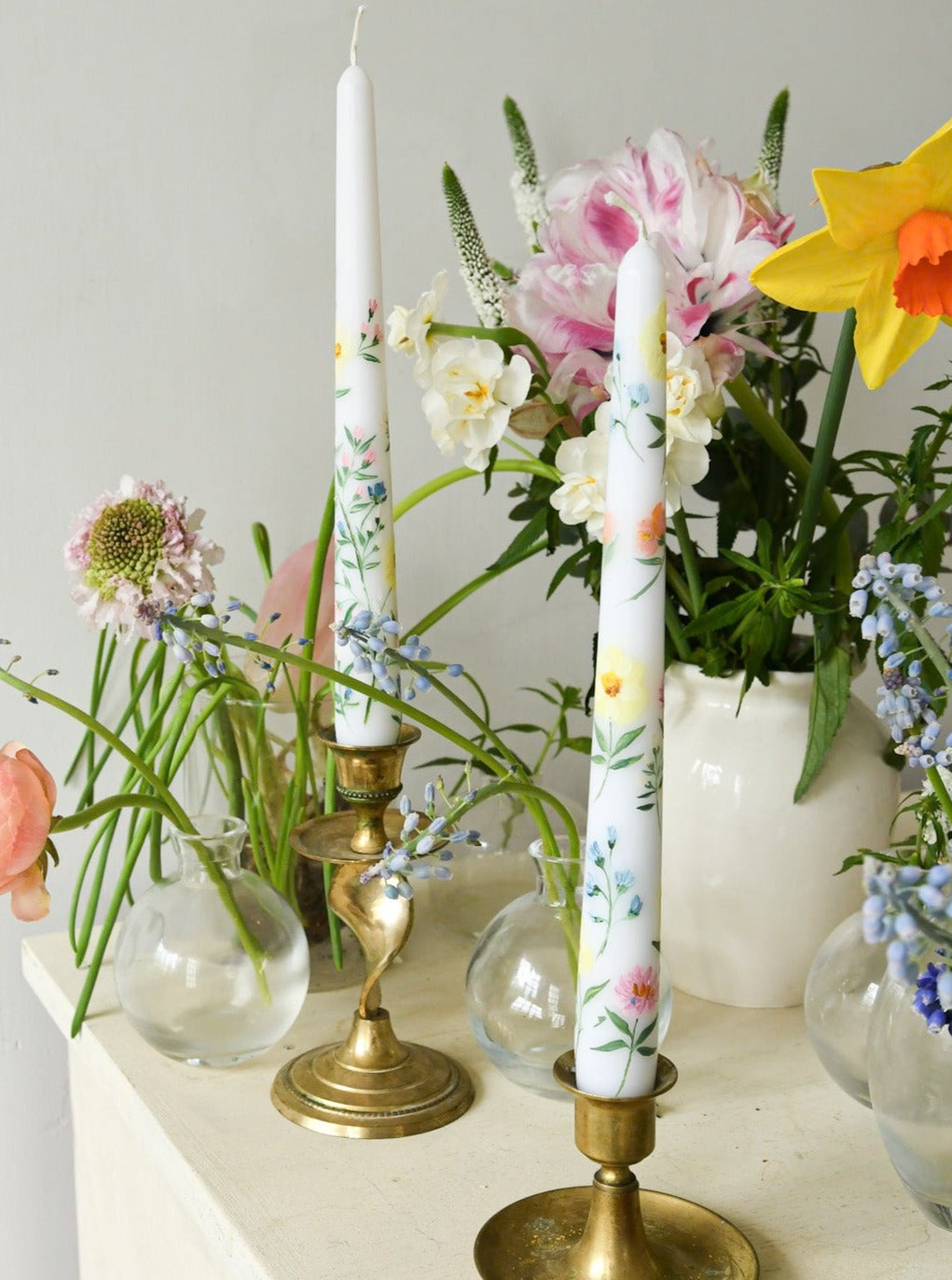 hand painted white floral candle surrounded by primrose flowers