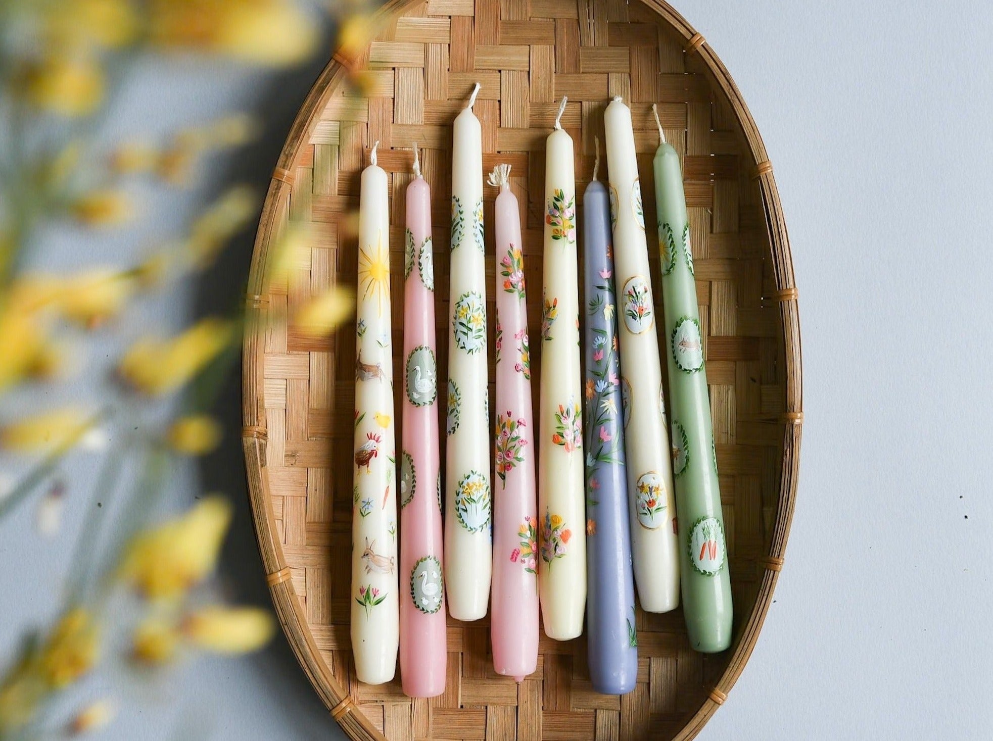 hand painted easter candles in a basket