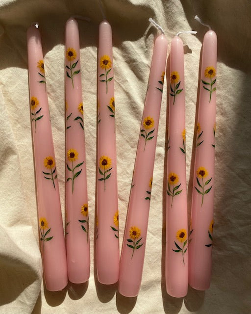 pink dinner candles are hand painted with yellow sunflowers